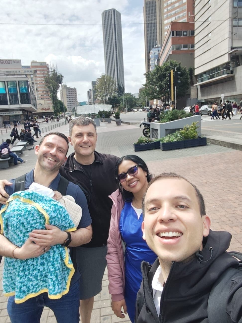 Una gestante junto a los padres intencionales y su bebé recién nacido